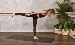 Kobieta w pozycji Virabhadrasana III, ćwicząca mula bandha.