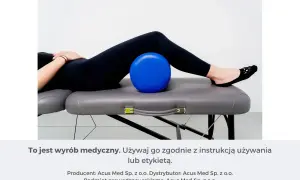 Osoba leży na kozetce, z niebieską piłką pod odcinkiem lędźwiowym. To pomoc w ćwiczeniach na rwę kulszową.