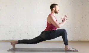 Mężczyzna w pozycji jogi na macie, ćwiczący **joga multisport**.