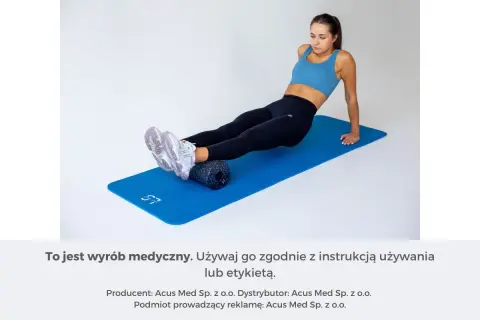 Kobieta wykonuje ćwiczenia na achillesa na wałku do masażu.