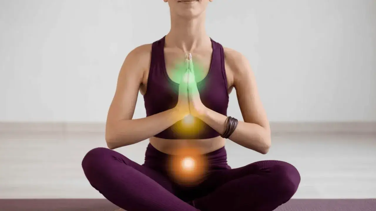 Kobieta w pozycji medytacyjnej, z widocznymi energetycznymi ogniskami. Uważaj na kundalini niebezpieczeństwa podczas praktyki.